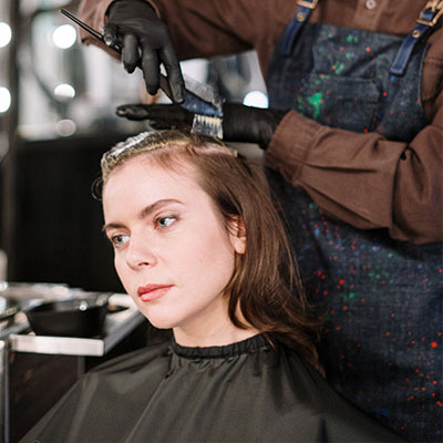 Image d'une femme en train de recevoir des couleurs capillaires au salon Nuance Coiffure.