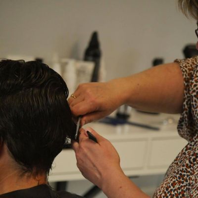 Image d'une femme en train de recevoir une coupe et une coiffage de cheveux au salon Nuance Coiffure.